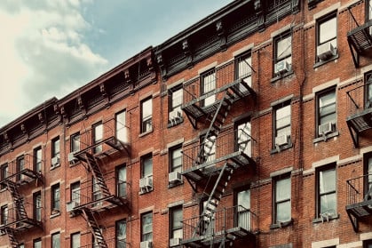 brick apartment building adorned with iconic fire escapes.